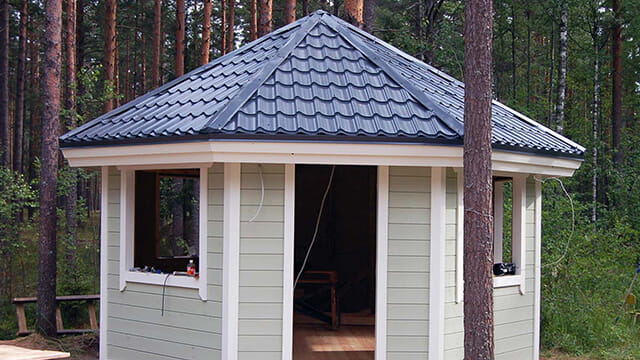 Закрытая беседка, обшитая сайдингом с крышей из металлочерепицы