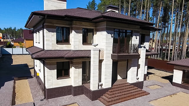 Двухэтажный дом с кровлей из битумной черепицы
